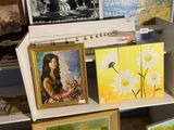 de nombreux tableaux exposés sur une étagère dans une pièce