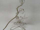 a clear glass table lamp with a gold shade on top of it