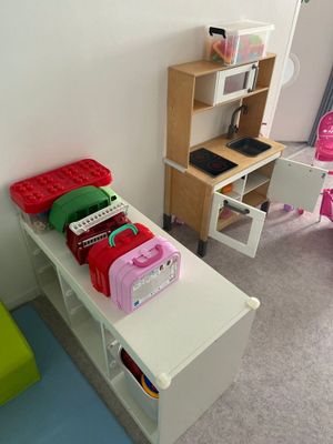 une table blanche avec une chaise rose et une chaise verte dans un coin