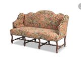 a couch with a floral upholstered back and arms
