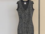a black and white dress hanging on a rack in front of a wall