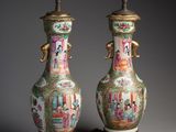 pair of chinese vases with figures on stands on a gray background