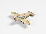 un petit avion miniature posé sur une surface blanche