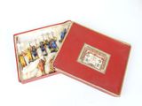 a red box with figurines in it on a white surface