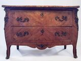 a wooden chest of drawers with a marble top