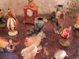 many figurines on a table with a clock in the background