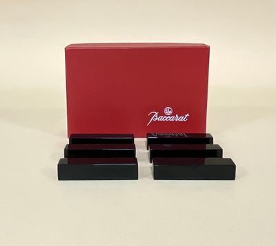 une paire de serre-livres noirs et rouges, avec une boîte rouge posée sur une surface blanche