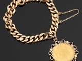 un bracelet en or orné d'une pièce et entouré d'une chaîne