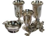 four silver cups and a bowl on a white background