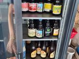 a woman standing in front of a refrigerator filled with beer