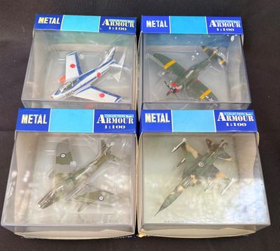 trois boîtes contenant des maquettes d'avions en métal, posées sur une surface noire