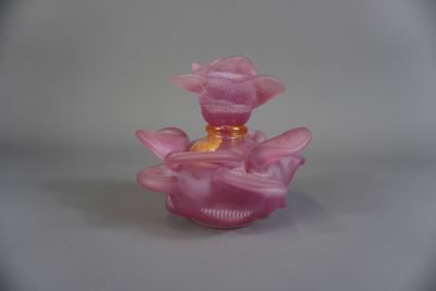 une petite bougie rose posée sur une table