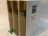 three books that are sitting on a white surface