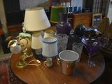 a table with a lamp, cups, and other items on it