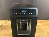 a black coffee machine sitting on top of a wooden table