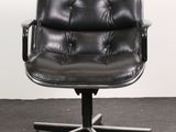an image of a black leather office chair sitting on top of a carpeted floor
