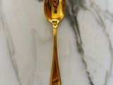 a gold spoon sitting on a marble counter top