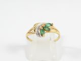 a close up of a gold ring with two emerald stones