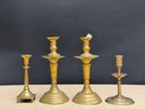 three brass candlesticks on a table with a black background