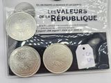 three silver coins in a plastic bag with a price tag