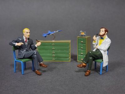 deux figurines représentant un homme et une femme assis sur une chaise