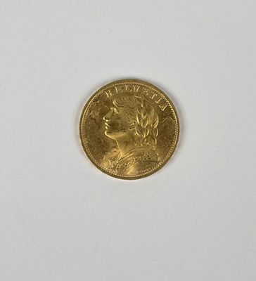 gros plan d'une pièce d'or sur une surface blanche