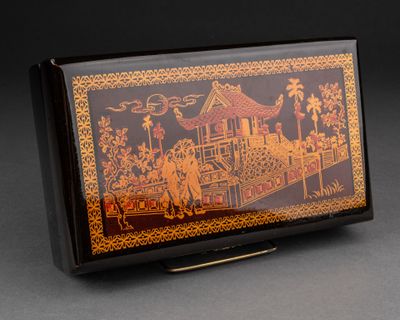une boîte noire et dorée sur laquelle est représentée une peinture