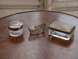 deux objets en argent posés sur une table en bois près d'une fenêtre
