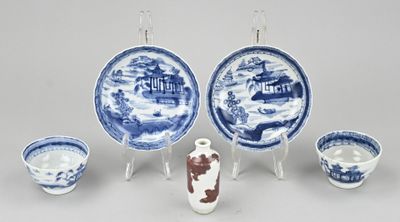 plusieurs assiettes et bols bleus et blancs, ainsi qu'un vase posé sur un socle