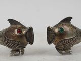 paire de salières et poivrières en forme de poissons argentés, aux yeux rouges et verts