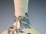 a blue and white vase with birds painted on it