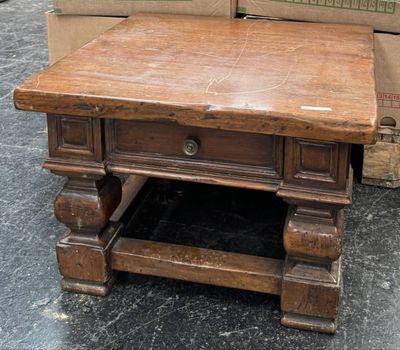 une table en bois posée à même le sol, avec un tiroir en dessous