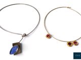 une paire de boucles d'oreilles créoles en argent ornées d'une pierre bleue et d'une pierre rouge