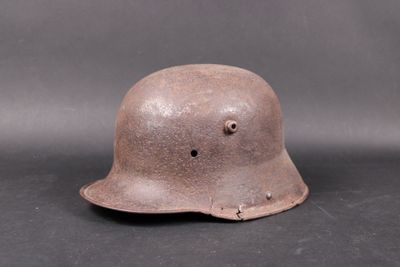 an old helmet with holes on the side of it on a black surface