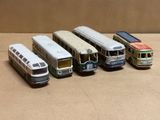 cinq petits bus alignés en rang sur une table