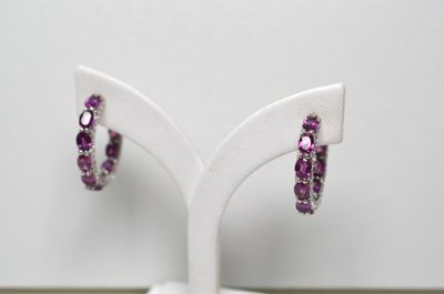 une paire de boucles d'oreilles en améthorate et diamants, présentées sur un socle blanc
