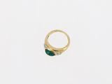 a close up of a gold ring with a green stone