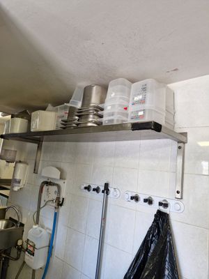 de nombreuses casseroles et poêles sur les étagères de la cuisine