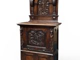 une vieille armoire en bois ornée de sculptures sur le dessus