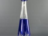 an image of a blue glass decanter on a gray background
