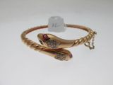 a close up of a gold bracelet with a snake on it