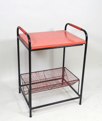an image of a red metal shelf with a basket underneath it