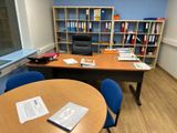 un bureau avec une chaise et une étagère dans le coin