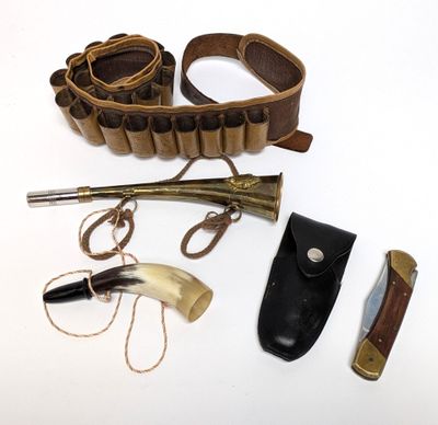 un couteau, un porte-couteau et d'autres objets posés sur une surface blanche