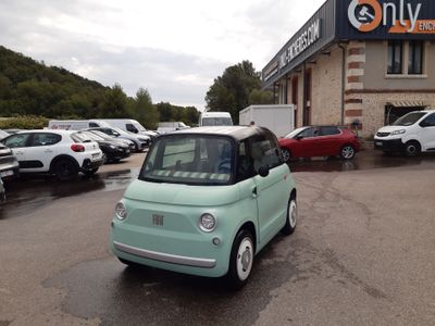 une petite voiture verte garée devant un immeuble
