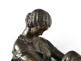 a bronze statue of a woman reading a book