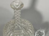 a small glass bottle and a small silver object on a table