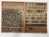 a wooden box filled with letters and a bunch of rocks