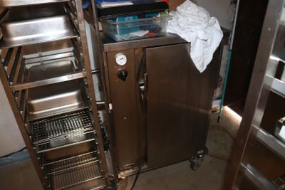 une petite cuisine équipée d'un meuble en inox et d'étagères