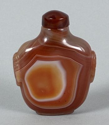 a picture of a glass bottle with a brown and white design on it